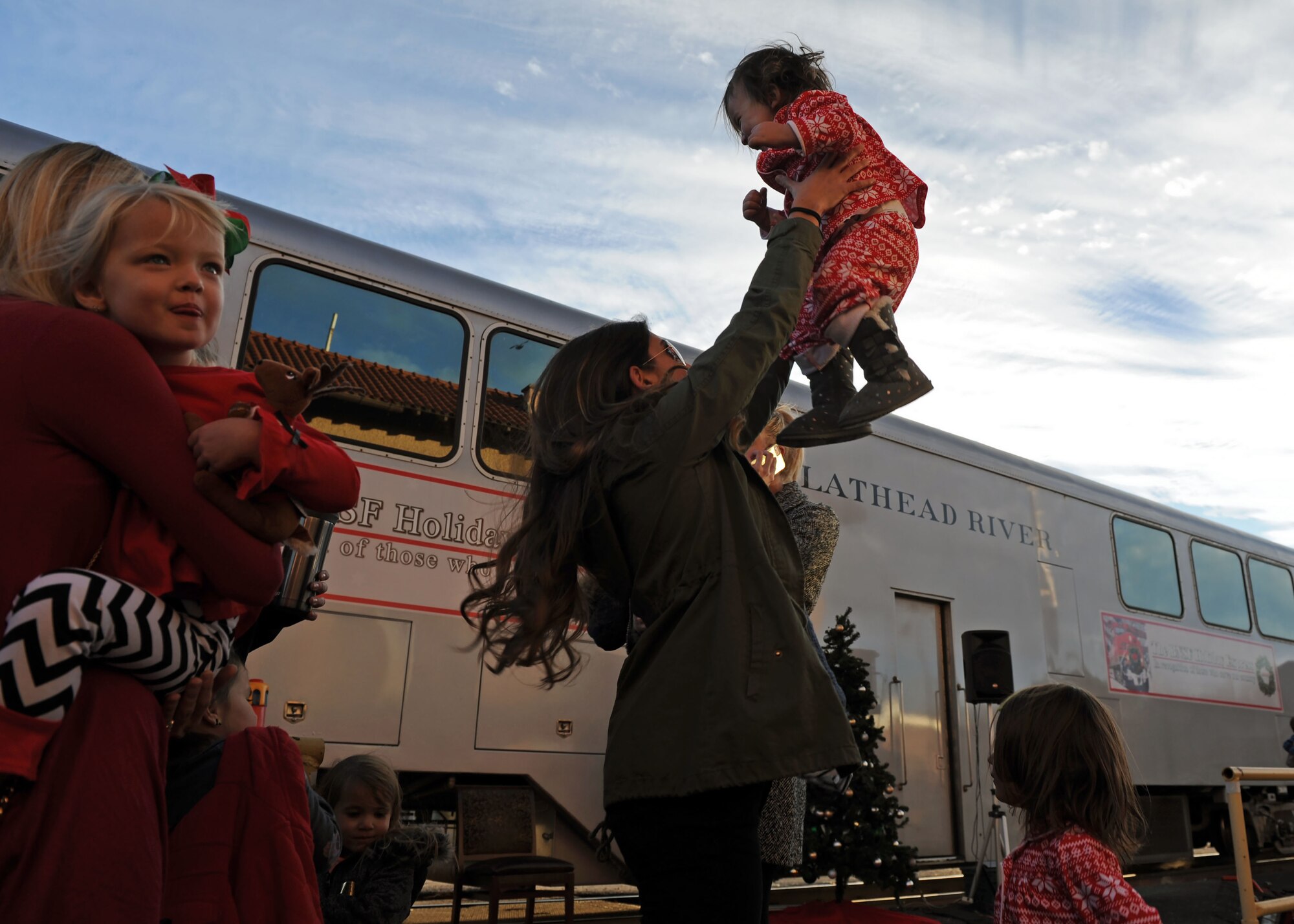 A mother and daughter from Cannon Air Force Base, N.M., play together while waiting to board the Holiday Express, Dec. 1, 2016, at a railyard in downtown Clovis, N.M. For nine consecutive years, the BNSF Railway has invited service members and their loved ones aboard the Holiday Express to enjoy milk, cookies, and a visit from Santa Claus to show their appreciation. (U.S. Air Force photo by Staff Sgt. Whitney Amstutz/Released)