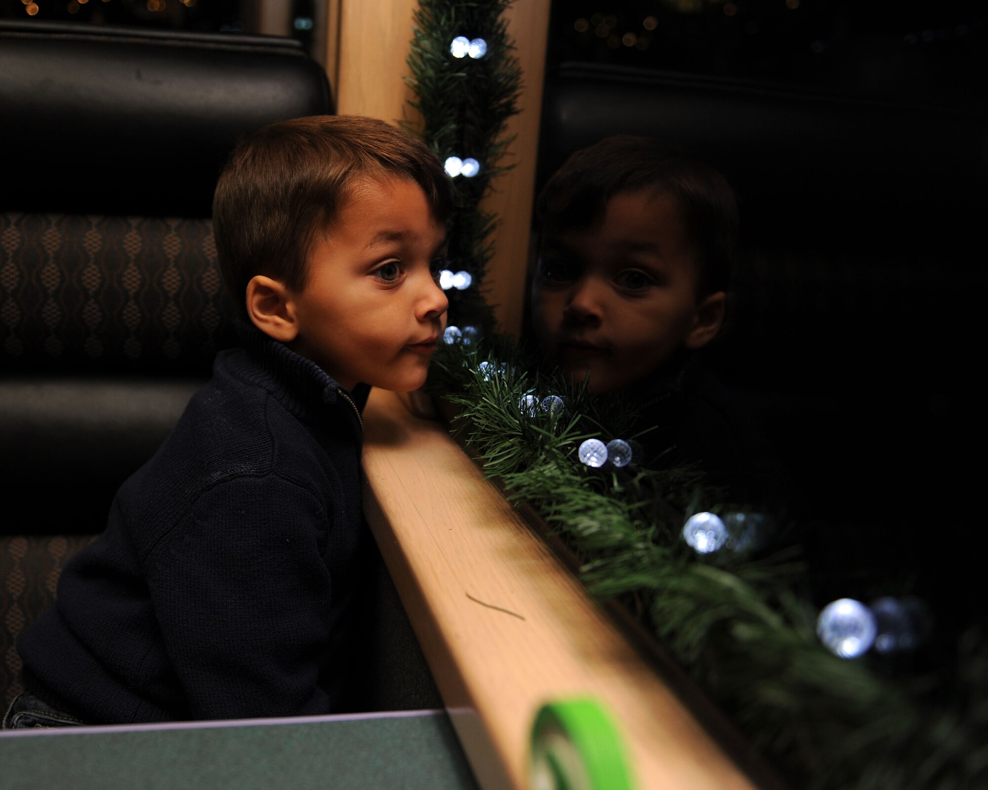 A dependent from Cannon Air Force Base, N.M., looks out the window of the Holiday Express, Dec. 1, 2016, in Clovis, N.M. For nine consecutive years, the BNSF Railway has invited service members and their loved ones aboard the Holiday Express to enjoy milk, cookies, and a visit from Santa Claus to show their appreciation. (U.S. Air Force photo by Staff Sgt. Whitney Amstutz/Released)