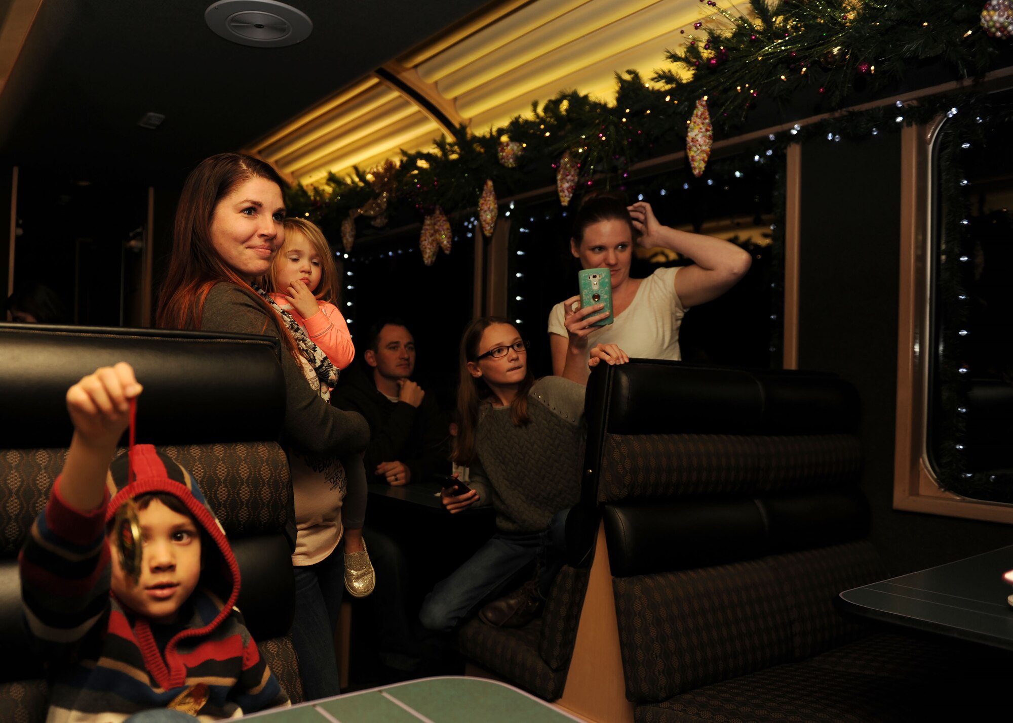 Parents and children wait to take photos with Santa Claus aboard the Holiday Express, Dec. 1, 2016, in Clovis, N.M. For nine consecutive years, the BNSF Railway has invited service members and their loved ones aboard the Holiday Express to enjoy milk, cookies, and a visit from Santa Claus to show their appreciation. (U.S. Air Force photo by Staff Sgt. Whitney Amstutz/Released)