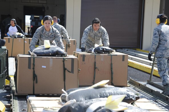 U.S. Air Force Senior Airmen Geralyn Lunod and Paul Ibanez, air transportation specialists with the Air Force Reserve's 44th Aerial Port Squadron, push a Christmas box on the 60K loader at Andersen Air Force Base, Guam, Dec. 7, 2016. Operation Christmas Drop is the longest running humanitarian airlift operation in the history of the Department of Defense, impacting the lives of more than 20,000 islanders. The people of the Micronesian islands can expect to see service members aboard a C-130 Hercules drop a box, attached to a parachute, filled with rice, fish hooks, educational materials, clothing and toys. The 44th Aerial Port Squadron supports the 624th Regional Support Group's mission to deliver mission essential capability through combat readiness, quality management and peacetime deployments in the Pacific area of responsibility. (U.S. Air Force photo by Master Sgt. Theanne Herrmann)