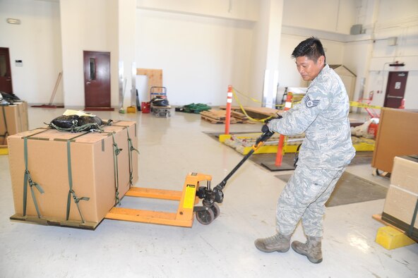 U.S. Air Force Staff Sgt. Nelson Dacanay, air transportation specialist with the Air Force Reserve's 44th Aerial Port Squadron, moves Christmas boxes into place so they can be loaded onto a C-130 Hercules as a part of the 65th Operation Christmas Drop at Andersen Air Force Base, Guam, Dec. 7, 2016. Operation Christmas Drop is the longest running humanitarian airlift operation in the history of the Department of Defense, impacting the lives of more than 20,000 islanders. The people of the Micronesian islands can expect to see service members aboard a C-130 Hercules drop a box, attached to a parachute, filled with rice, fish hooks, educational materials, clothing and toys. The 44th Aerial Port Squadron supports the 624th Regional Support Group's mission to deliver mission essential capability through combat readiness, quality management and peacetime deployments in the Pacific area of responsibility. (U.S. Air Force photo by Master Sgt. Theanne Herrmann)