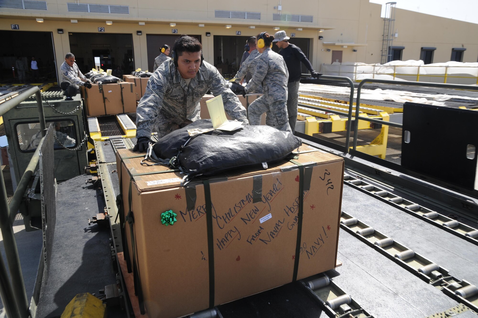 U.S. Air Force Senior Airman Paul Ibanez, an  air transportation specialists with the Air Force Reserve's 44th Aerial Port Squadron, pushes a Christmas box on to the back of a 60K loader as a part of the 65th Operation Christmas Drop, at Andersen Air Force Base, Guam, Dec. 7, 2016. Operation Christmas Drop is the longest running humanitarian airlift operation in the history of the Department of Defense, impacting the lives of more than 20,000 islanders. The people of the Micronesian islands can expect to see service members aboard a C-130 Hercules drop a box, attached to a parachute, filled with rice, fish hooks, educational materials, clothing and toys. The 44th Aerial Port Squadron supports the 624th Regional Support Group's mission to deliver mission essential capability through combat readiness, quality management and peacetime deployments in the Pacific area of responsibility. (U.S. Air Force photo by Master Sgt. Theanne Herrmann)