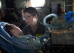 2nd Lt. Andrea Perez, member of the 59th Medical Wing Acute Lung Rescue Transport team, monitor a patient onboard a C-130J Super Hercules, Dec. 12, 2016. The 59th Medical Wing’s Acute Lung Rescue Team provided medical care for a military dependent, during the four-hour flight.. (U.S. Air Force photo/Staff Sgt. Jason Huddleston)