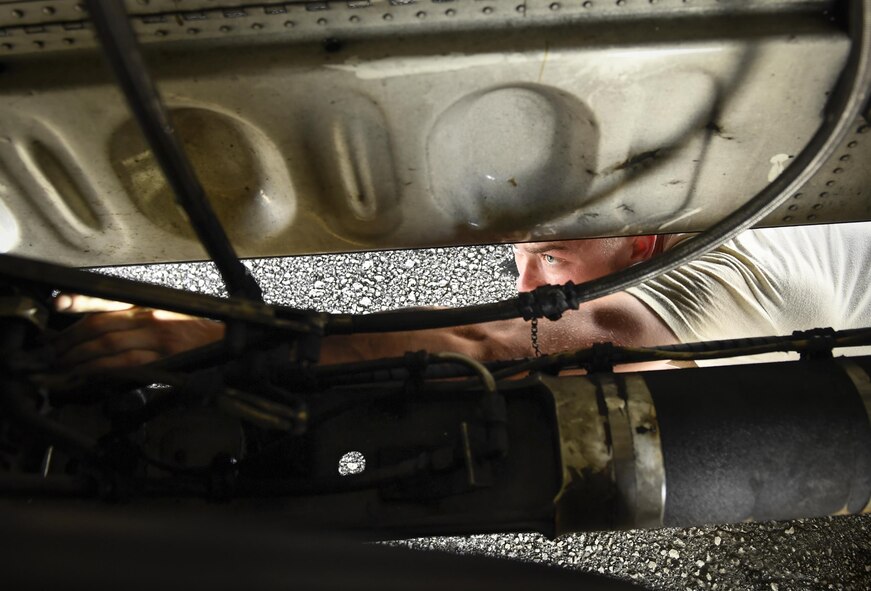 Senior Airman Benjamin Campanella, 374th Maintenance Group crew chief, inspects the underside of C-130H Hercules during Operation Christmas Drop 2016 at Andersen Air Force Base, Dec. 7, 2015. Every time 36th Airlift Squadron air crew performed their mission of airlifting gifts and supplies to the Micronesian Islands, Campanella and the rest of the MXG team first inspected each aircraft to ensure their safety and optimal performance. (U.S. Air Force photo by Senior Airman Elizabeth Baker/Released)