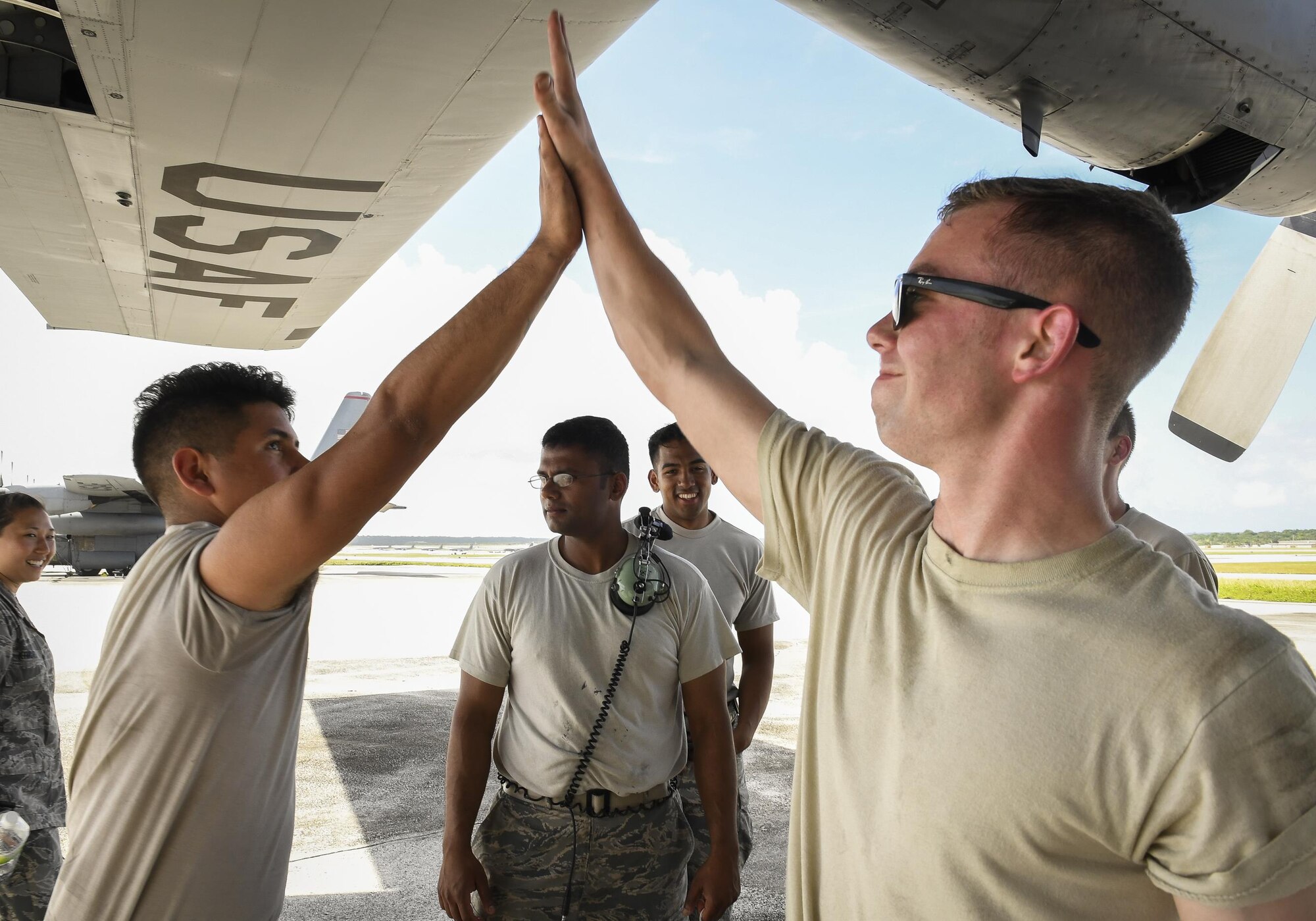 Senior Airman John Huarte, left, 374the Maintenance Group communication and navigation systems journeyman, and Senior Airman Benjamin Campanella, 374 MXG crew chief, celebrate successful aircraft repairs during Operation Christmas Drop 2016 at Andersen Air Force Base, Dec. 7, 2015. During OCD, the 374 MXG team kept Yokota Air Base’s C-130H Hercules flying daily so that they could deliver bundles of donated goods to the Micronesian Islands for training and Christmas celebration. (U.S. Air Force photo by Senior Airman Elizabeth Baker/Released)