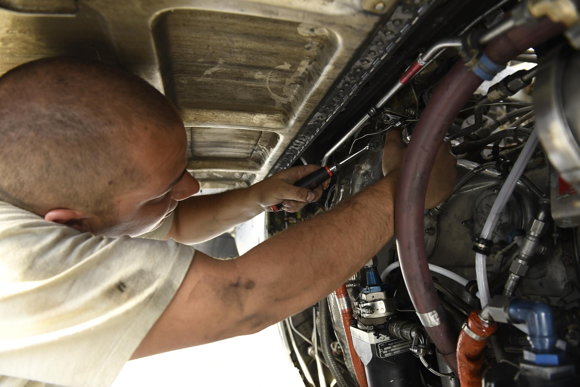 Senior Airman Markus Kay, 374th Maintenance Group hydraulics journeyman, repairs the engine of a C-130H Hercules during Operation Christmas Drop 2016 at Andersen Air Force Base, Dec. 7, 2015. 374 MXG maintainers were able to repair any malfunctioning aircraft in time to put it back to work by the next day. (U.S. Air Force photo by Senior Airman Elizabeth Baker/Released)