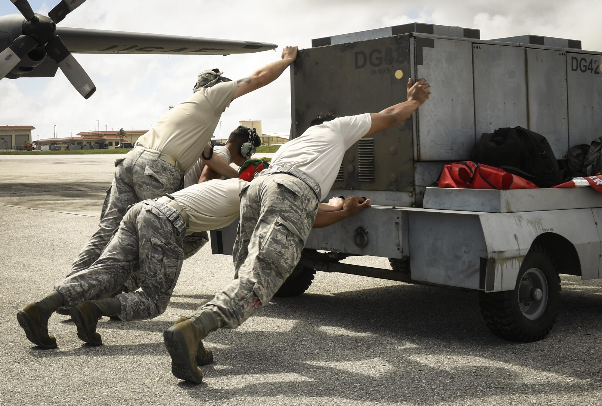 Members of the 374th Maintenance Group move a power cart in preparation of a C-130H Hercules takeoff at Andersen Air Force Base, Dec. 7, 2015. The 374 MXG made sure C-130s remained operational so that air crews could perform their mission of airlifting bundles of donated gifts and supplies to the Micronesian Islands for Operation Christmas Drop 2016. (U.S. Air Force photo by Senior Airman Elizabeth Baker/Released)