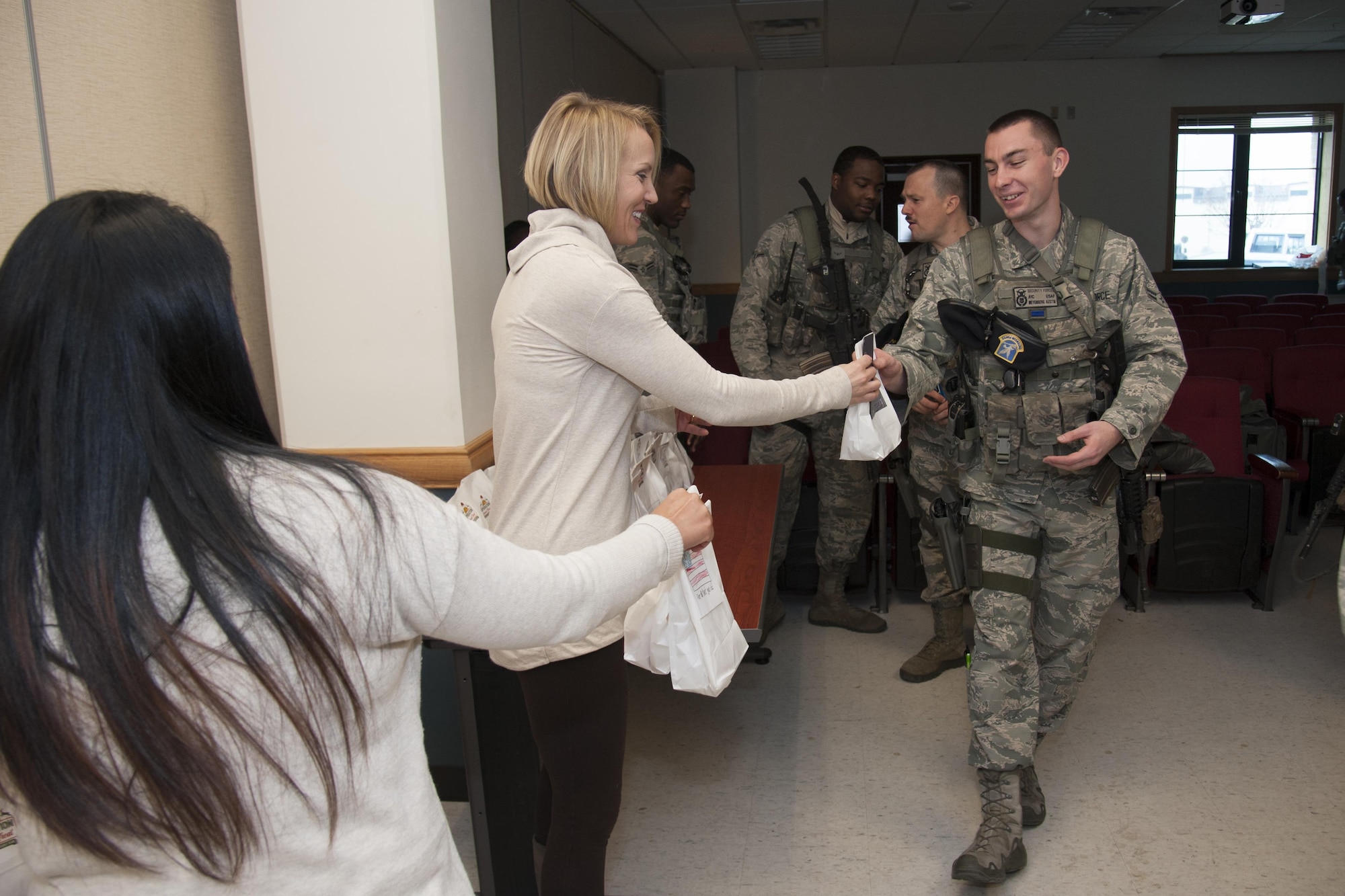 Shaneta Sandoval and Heidi Ringer from the Team Osan Spouse’s Club hand out bags of cookies to 51st Security Forces Squadron members during Operation Sweet Treat 2016 on Osan Air Base, Republic of Korea, Dec. 13, 2016. Team Osan Spouses Club sponsored the program that delivered bags of holiday cheer to Osan, Kunsan, Yongsan and Suwon Airmen and Soldiers.  (U.S. Air Force photo by Staff Sgt. Jonathan Steffen)