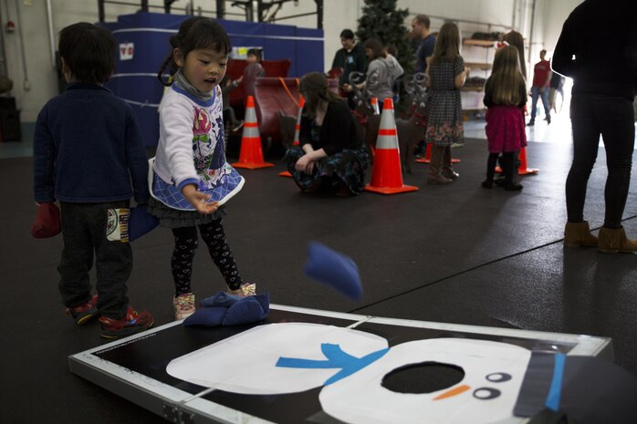 Cocona, a child from ARFF Tsuta Orphanage, plays corn hole during the ARFF Tsuta Christmas party at Marine Corps Air Station Iwakuni, Japan, Dec. 10, 2016. ARFF holds the event annually to help spread Christmas cheer to the orphans and to bring service members, their families and the Japanese together. Activities such as a bouncy house, Christmas cookie decorating and games were available to the children during the event. (U.S. Marine Corps photo by Lance Cpl. Gabriela Garcia-Herrera)