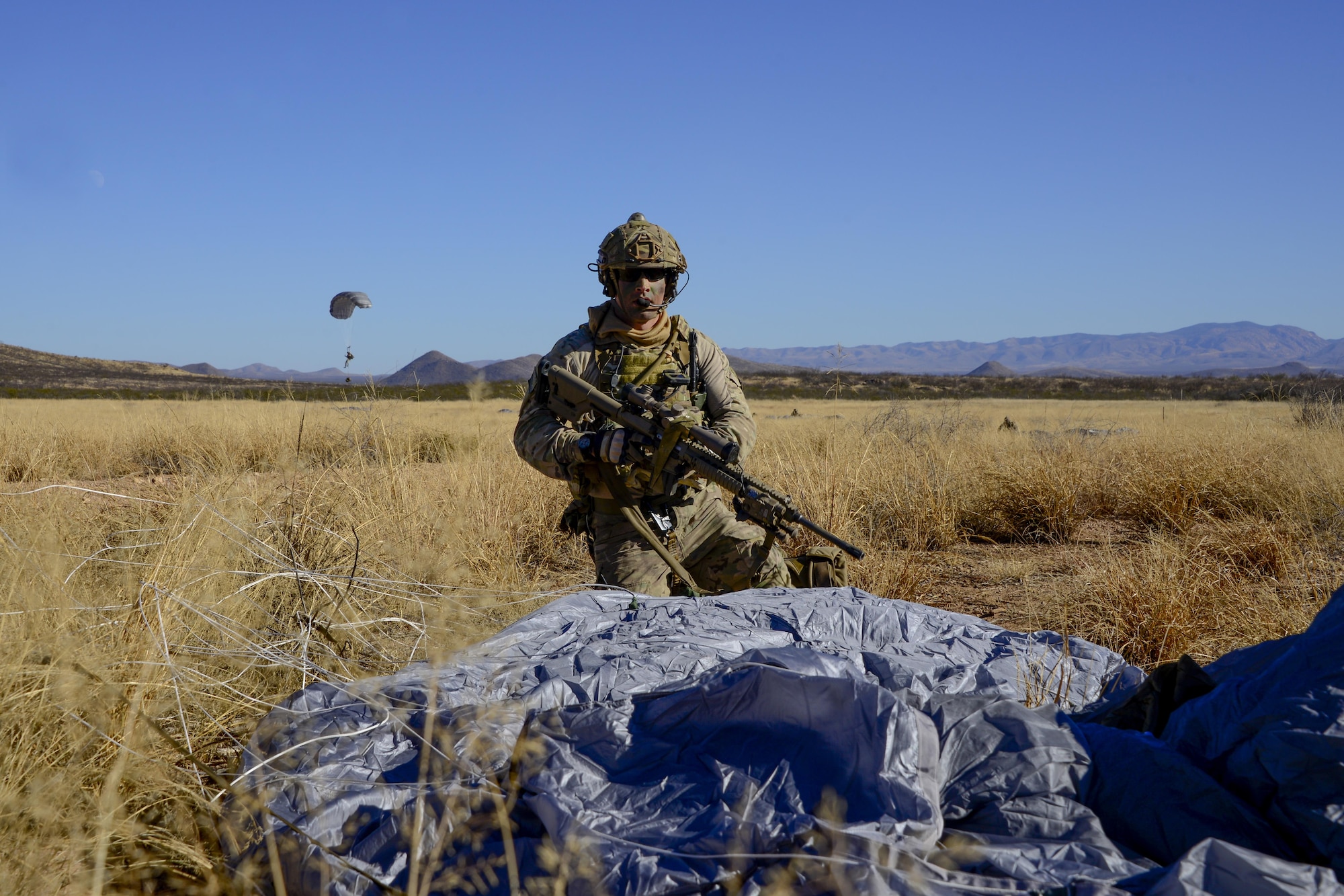 A U.S. Air Force pararescueman assigned to the 48th Rescue Squadron secures his landing site after parachuting from an HC-130J Combat King II at Fort Huachuca, Ariz., Dec. 8, 2016. Pararescuemen from the 48th RQS participated in a mass casualty exercise that involved a simulated plane crash resulting in 14 survivors in need of medical treatment. (U.S. Air Force photo by Senior Airman Betty R. Chevalier)