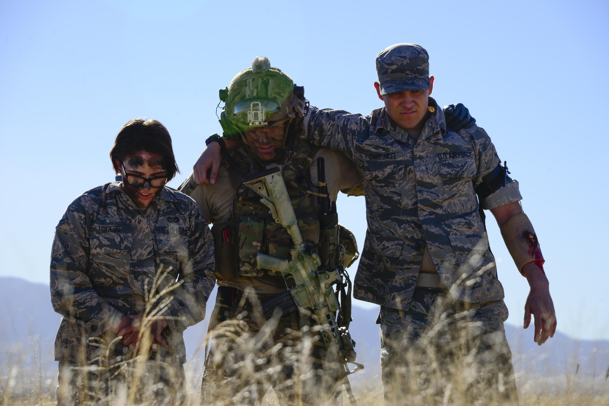 A U.S. Air Force pararescueman assigned to the 48th Rescue Squadron assists patients to a casualty collection point during a mass casualty exercise at Fort Huachuca, Ariz., Dec. 8, 2016. Pararescuemen were dispatched and air dropped over the site of a simulated plane crash, where they sifted through the wreckage and treated survivors. (U.S. Air Force photo by Senior Airman Betty R. Chevalier)