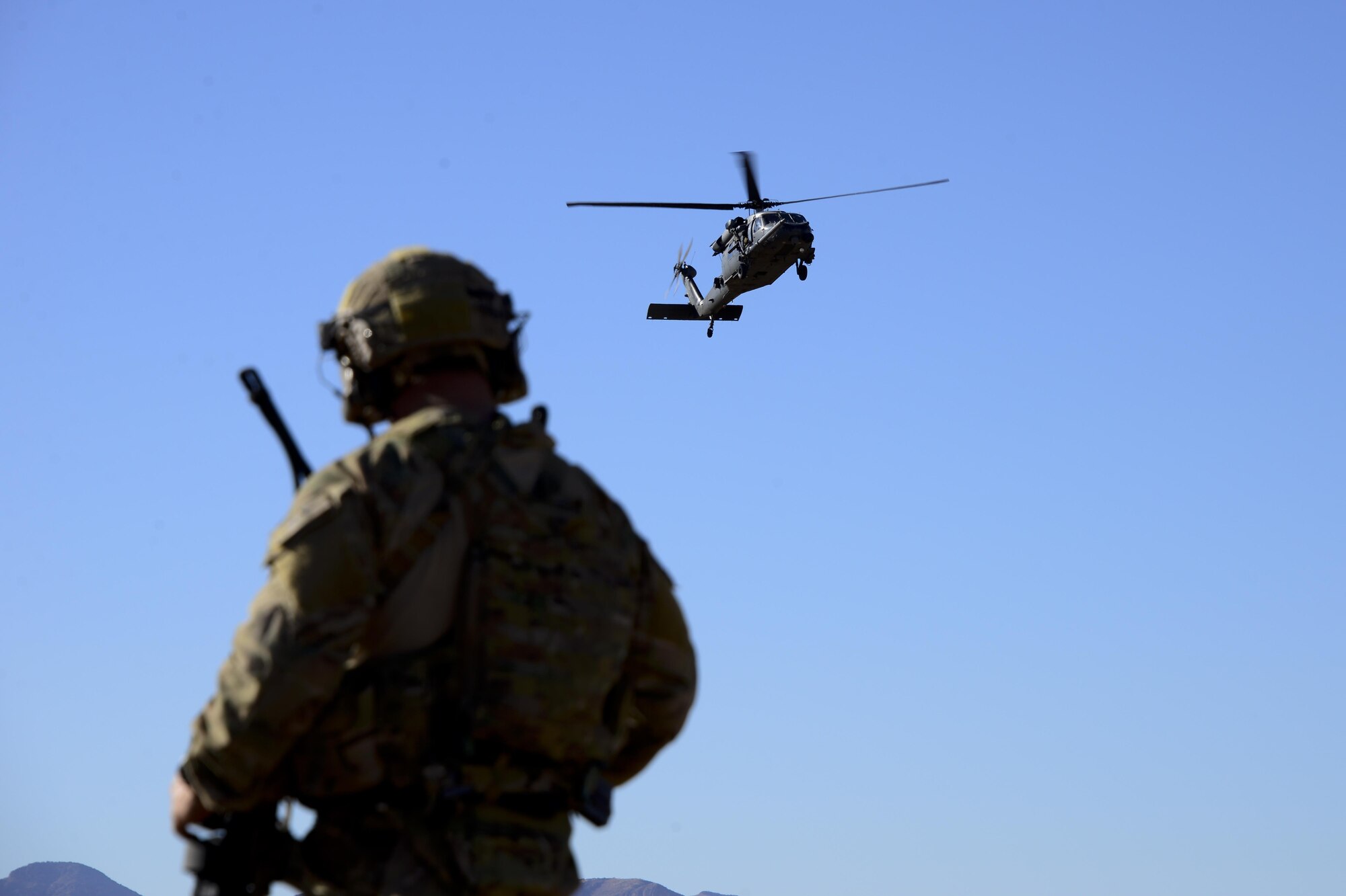 A U.S. Air Force pararescueman assigned to the 48th Rescue Squadron observes an HH-60G Pave Hawk assigned to the 55th Rescue Squadron during a mass casualty exercise at Fort Huachuca, Ariz., Dec. 8, 2016. Pararescuemen were air dropped into a simulated plane crash site, where they triaged casualties and evacuated them from the site via the HH-60s. (U.S. Air Force photo by Senior Airman Betty R. Chevalier)