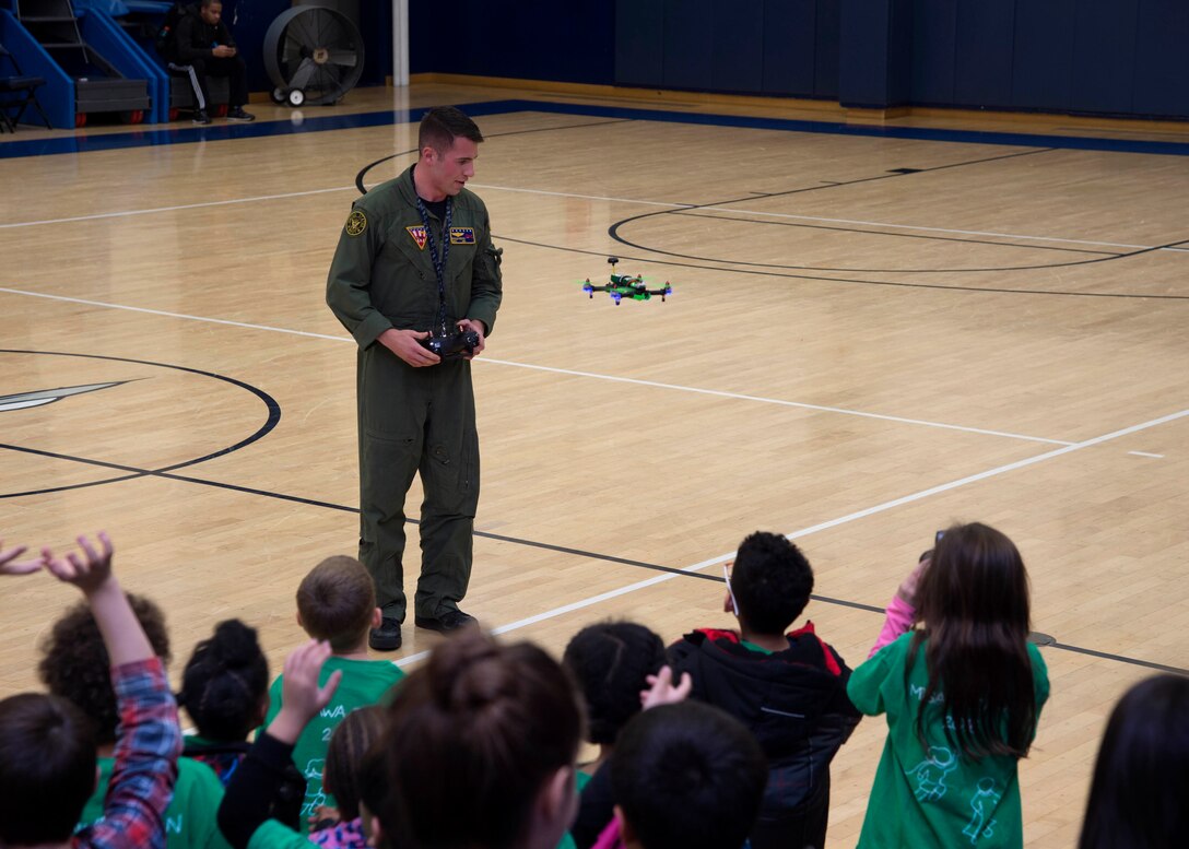 U.S. Navy Petty Officer 2nd Class Morgan Reeves, Naval Air Facility Misawa UC-12F Huron crewman, pilots his quadcopter drone to Misawa teen center children during a drone safety symposium at Misawa Air Base, Japan, Dec. 8, 2016. Reeves explained to children that drones are prohibited on-base and when flown off-base, they must be five nautical miles away from the flight line. (U.S. Air Force photo by Senior Airman Deana Heitzman)