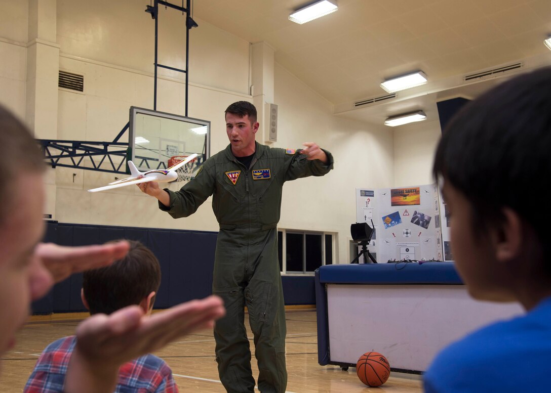 U.S. Navy Petty Officer 2nd Class Morgan Reeves, Naval Air Facility Misawa UC-12F Huron crewman, demonstrates basic flight fundamentals to Misawa teen center children during a drone safety symposium at Misawa Air Base, Japan, Dec. 8, 2016. The symposium was put together to highlight the safety precautions children must adhere to when flying drones off base. (U.S. Air Force photo by Senior Airman Deana Heitzman)