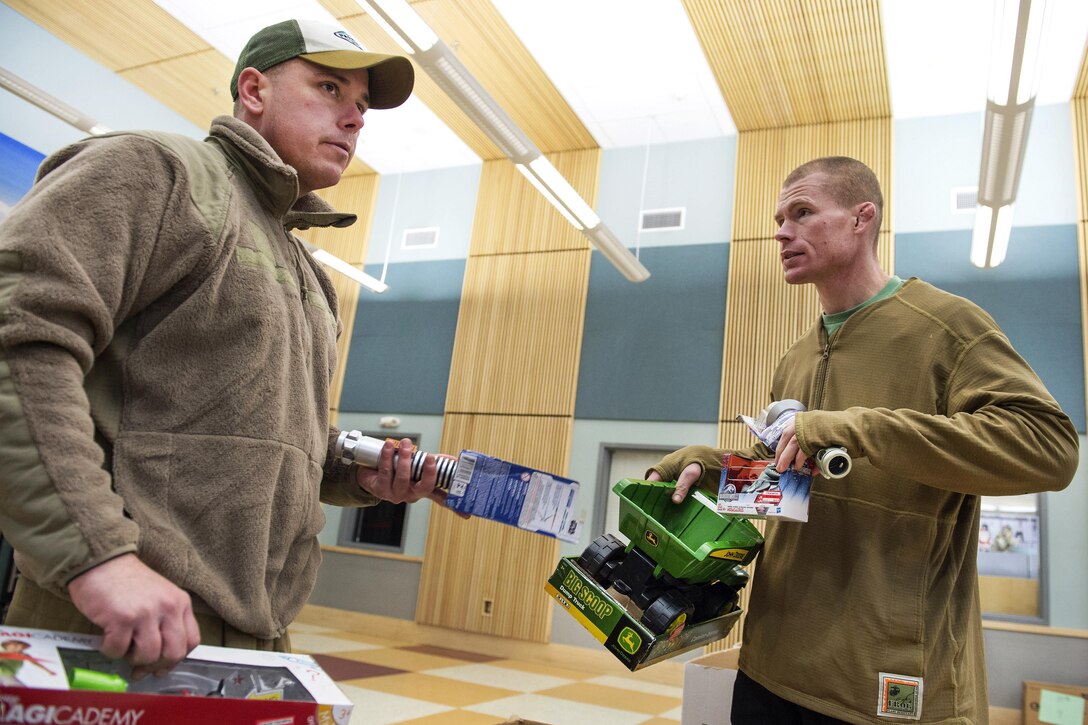 Marine Corps Capt. Michael Sickels, left, and 1st Sgt. Joshua Guffey gather toys while distributing holiday gifts to students at Napaaqtugmiut School in Noatak, Alaska, Dec. 3, 2016. Sickels and Guffey are assigned to Detachment Delta, 4th Law Enforcement Battalion. Two teams of Marines traveled via snow machine to 10 remote villages in the vicinities of Kotzebue to deliver toys to children during the holiday season. Toys for Tots is supported by the U.S. Marine Corps Reserve. Air Force photo by Alejandro Pena