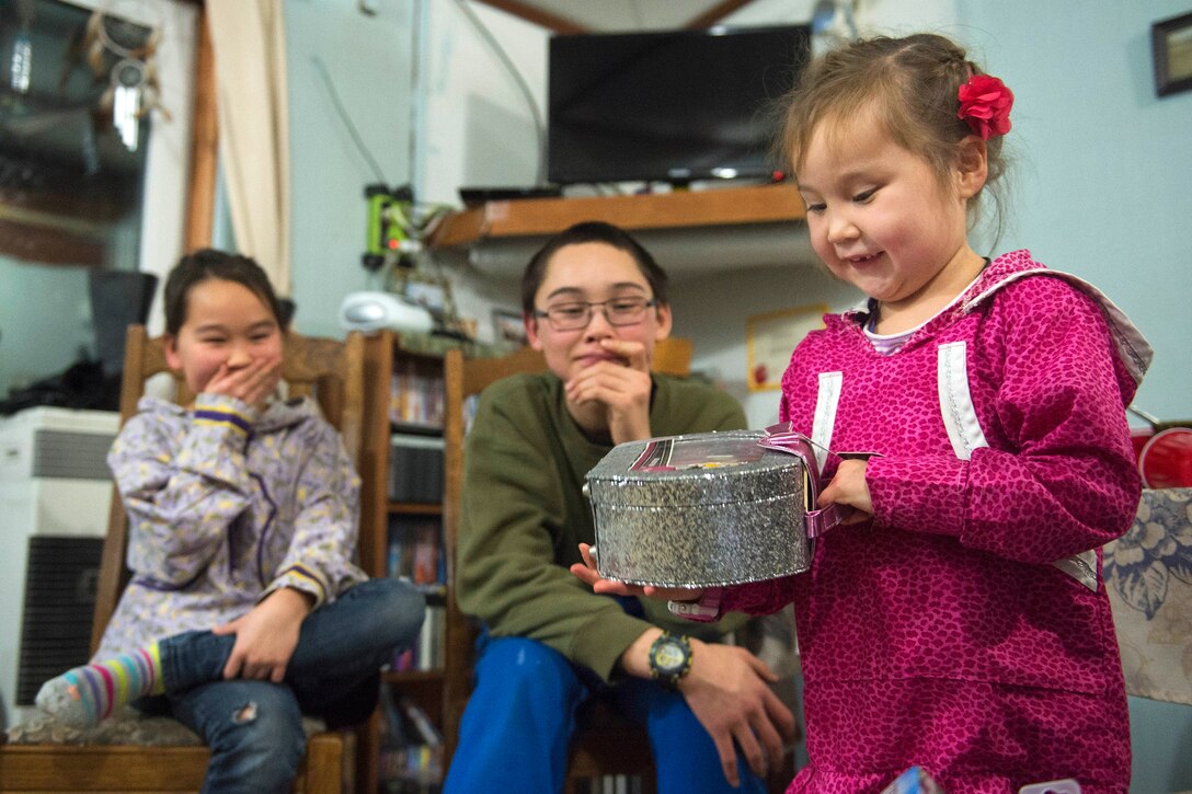 Shanelle, 6, right, picks out a present as her brother and sister wait their turn at Sikusuiliaq Hatchery, Alaska, Dec. 4, 2016. Air Force photo by Alejandro Pena