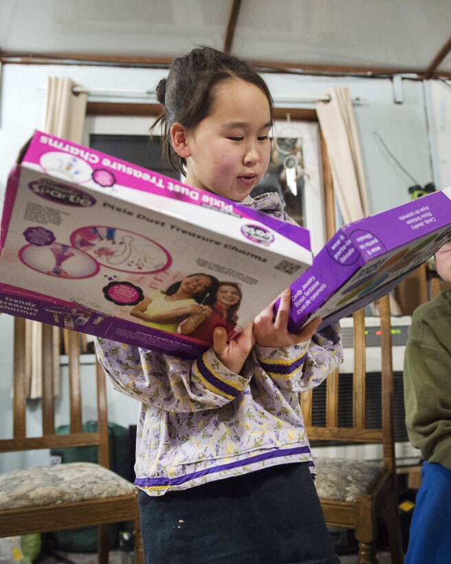 Audrey, 11, smiles after receiving presents from Santa Claus during Toys for Tots at Sikusuiliaq Hatchery, Alaska, Dec. 4, 2016. Air Force photo by Alejandro Pena