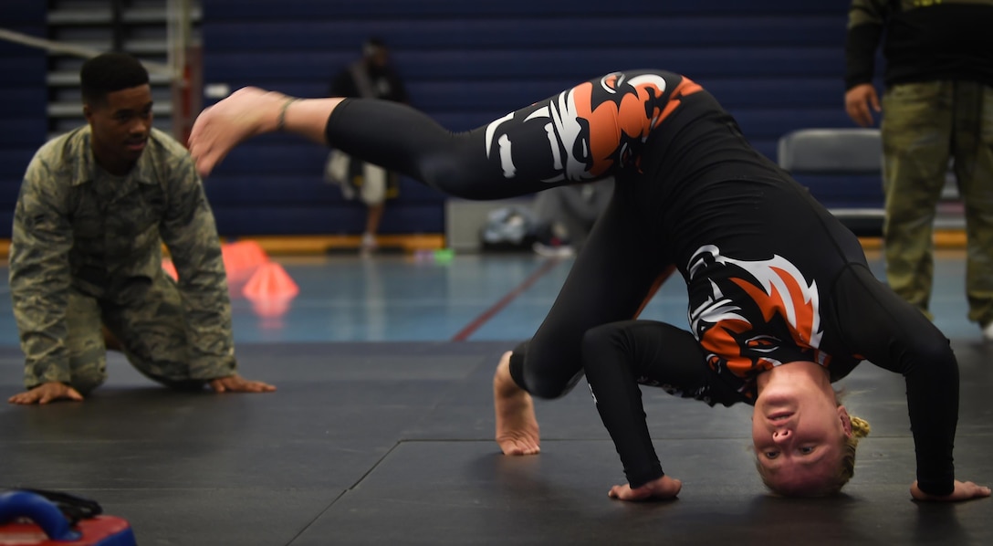 Valentina Shevchenko, UFC Bantamweight fighter, demonstrates a warm up stretch to U.S. Air Force Airmen before training at Joint Base Langley-Eustis, Va., Dec. 8, 2016. Shevchenko trained with the Airmen during a morale visit in preparation for an upcoming fight. (U.S. Air Force photo by Staff Sgt. Natasha Stannard)