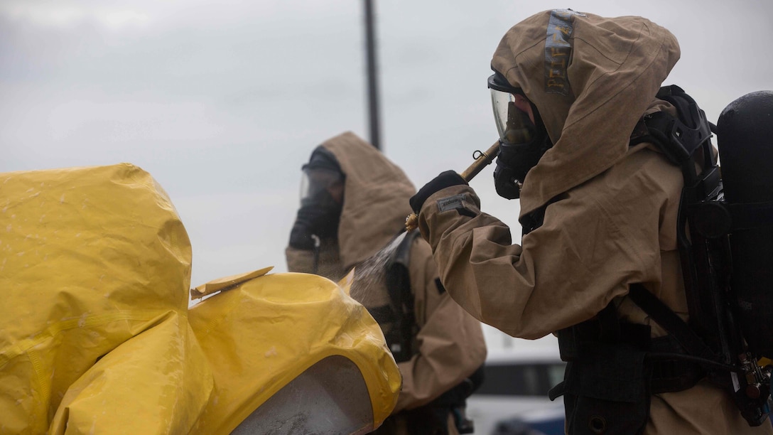U.S. Marines with Chemical Biological Radiological Nuclear decontamination team assigned to Headquarters Battalion, 3rd Marine Division, III Marine Expeditionary Force decontaminate the CBRN response element team following a simulated chemical spill on Camp McTureous, Okinawa, Japan, Dec. 13, 2016, as a part of exercise Constant Vigilance. Constant Vigilance is an annual Marine Corps Installations Pacific exercise designed to validate and refine incident response procedures and train personnel on actions required in the event of a natural disaster. 