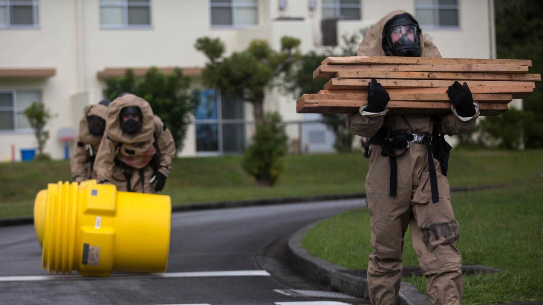 U.S. Marines with Chemical, Biological, Radiological and Nuclear Response Element from Headquarters Battalion, 3rd Marine Division, III Marine Expeditionary Force move supplies to a decontamination zone following a simulated chemical spill on Camp McTureous, Okinawa, Japan, Dec. 13, 2016, as a part of exercise Constant Vigilance. Constant Vigilance is an annual Marine Corps Installations Pacific exercise designed to validate and refine incident response procedures and train personnel on actions required in the event of a natural disaster.