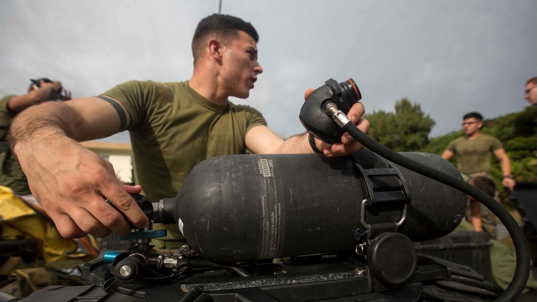 U.S. Marine Corps Cpl. Josh Hatfield, a Chemical Biological Radiological Nuclear Defense Specialist with Headquarters Battalion, 3rd Marine Division, III Marine Expeditionary Force, function checks his air tank on Camp McTureous, Okinawa, Japan, Dec. 13, 2016, as a part of exercise Constant Vigilance. Constant Vigilance is an annual Marine Corps Installations Pacific exercise designed to validate and refine incident response procedures and train personnel on actions required in the event of a natural disaster.