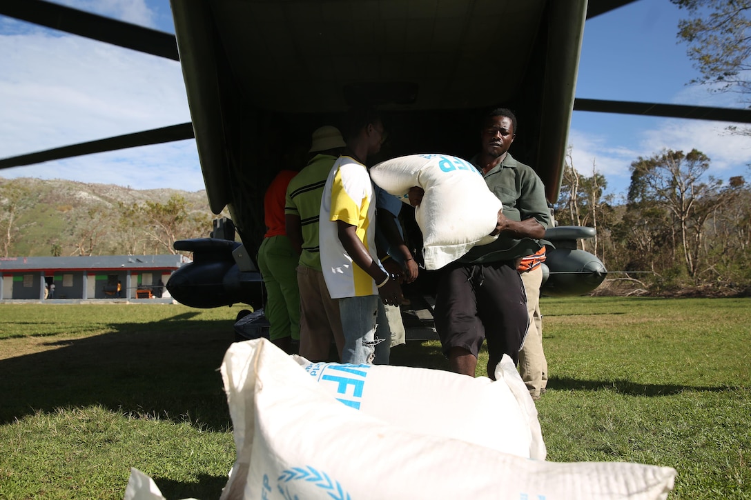 A Haitian man helps unload rice from the World Food Programme off of a CH-53 Super Stallion in Plaisance-du-Sud, Haiti, Oct 18, 2016. The Marines and sailors of with the 24th Marine Expeditionary Unit aboard USS Iwo Jima have been providing assistance to the U.S. government’s civil humanitarian aid and disaster relief efforts in Haiti in wake of Hurricane Matthew. The 24th MEU is committed to remaining the nation’s premier rapid crisis response force, providing the U.S. precious time in wake of a disaster, to coordinate a full-scale civil response. (U.S Marine Corps photo by Lance Cpl. Autmn S. Bobby)