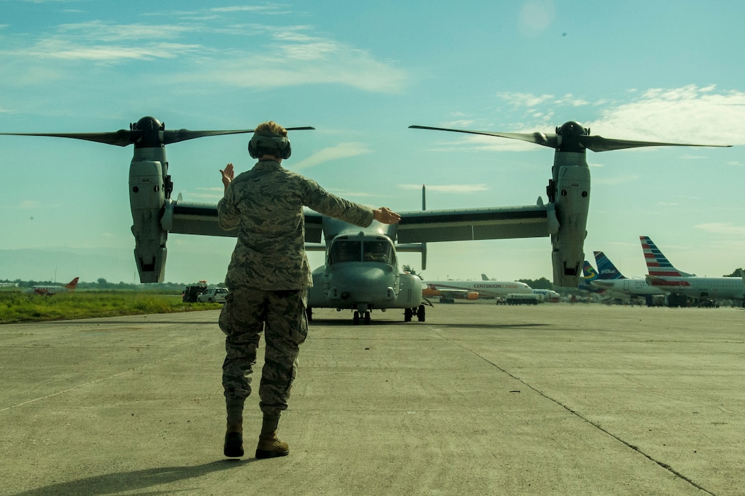 Staff Sgt. Jessie Hall, 621st Contingency Response Wing, marshalls a U.S. Marine Corps. V-22 Osprey at Port-Au-Prince, Haiti on October 14th, 2016.  The CRW is part of Joint Task Force Matthew a coordinated response to provide humanitarian aid to victims of Hurricane Matthew in Haiti. (U.S. Air Force photo by Staff Sgt. Robert Waggoner/released)