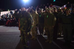 U.S. Air Force Master Sgt. Tuan Bui, 633rd Civil Engineer Squadron float participant, salutes the viewing stand with other volunteers from Joint Base Langley-Eustis during the Holly Days Parade in Hampton, Va., Dec. 10, 2016. More than 20 volunteers walked alongside the JBLE float that represented 100 Years of Langley. (U.S. Air Force photo by Senior Airman Kimberly Nagle)