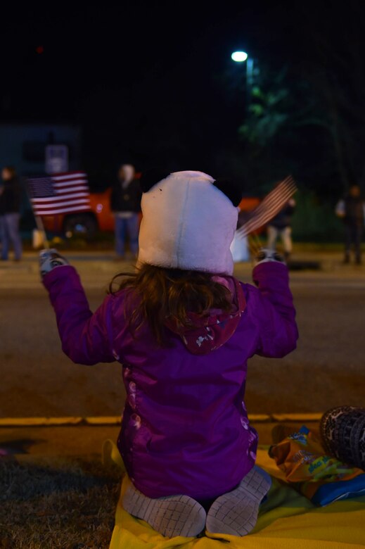 A child waves U.S. flags during the Holly Days Parade in Hampton, Va., Dec. 10, 2016. The streets of downtown Hampton were lined with parade watchers, who collected candy and high-fived parade members as floats drove by. (U.S. Air Force photo by Senior Airman Kimberly Nagle)