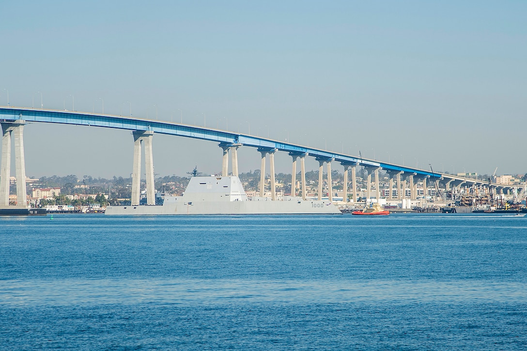 A tugboat escorts the USS Zumwalt under the Coronado Bridge and through San Diego Bay as the ship nears the end of the journey to its new home port in San Diego, Dec. 8, 2016. Navy photo by Petty Officer First Class Trevor Welsh
