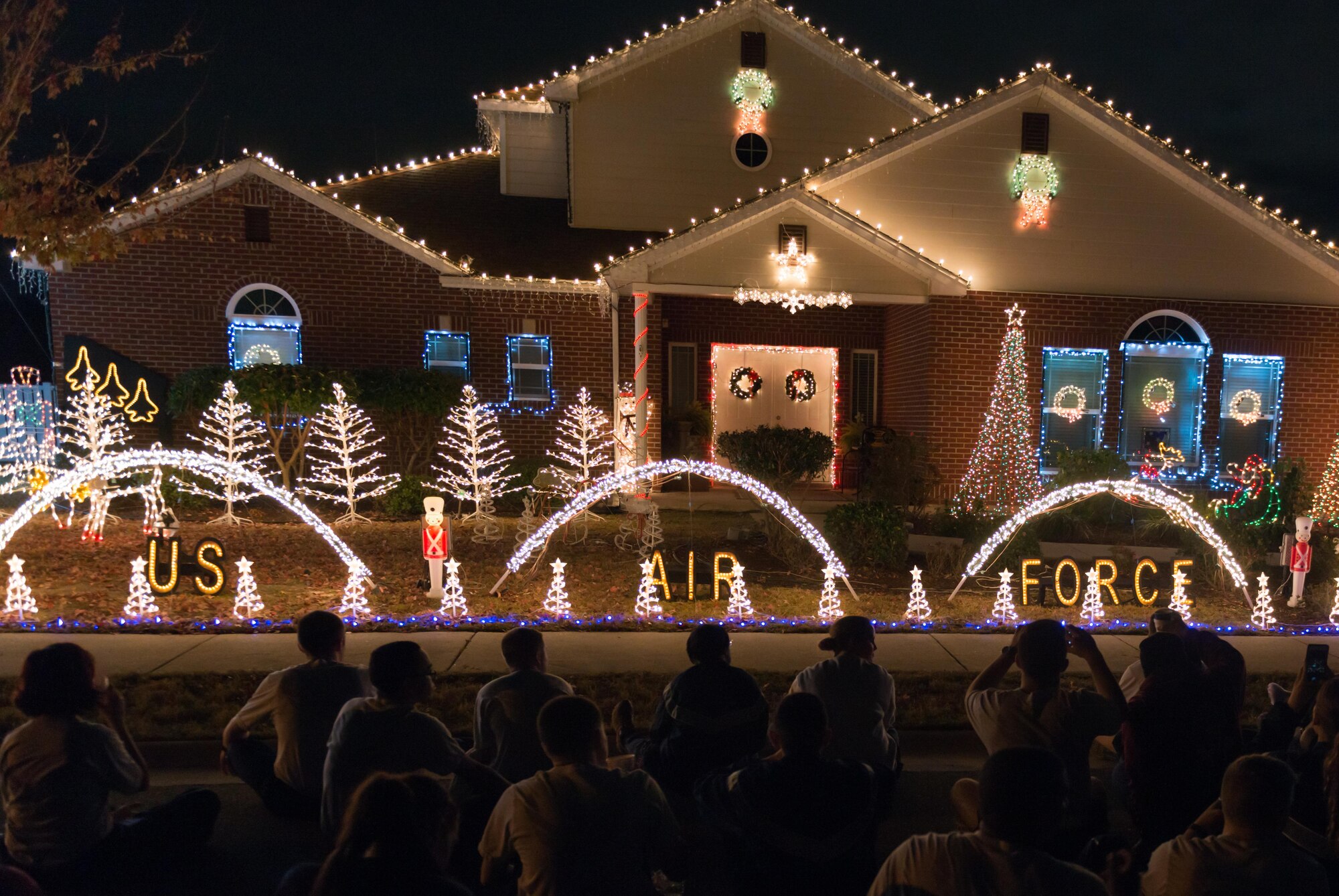 Members of the 81st Training Group watch a  light show display at Col. Scott Solomon, 81st TRG commander’s, house while eating cookies and drinking hot cocoa after a 5K “Toys for Tots” run, Dec. 11, 2016, on Keesler Air Force Base, Miss. The 5K run began at the Levitow Training Support Facility and ended in the Bayridge housing area. Each runner donated a toy to support of the U.S. Marine Corps Reserve Toys for Tots Program.  (U.S. Air Force Photo by Andre’ Askew)