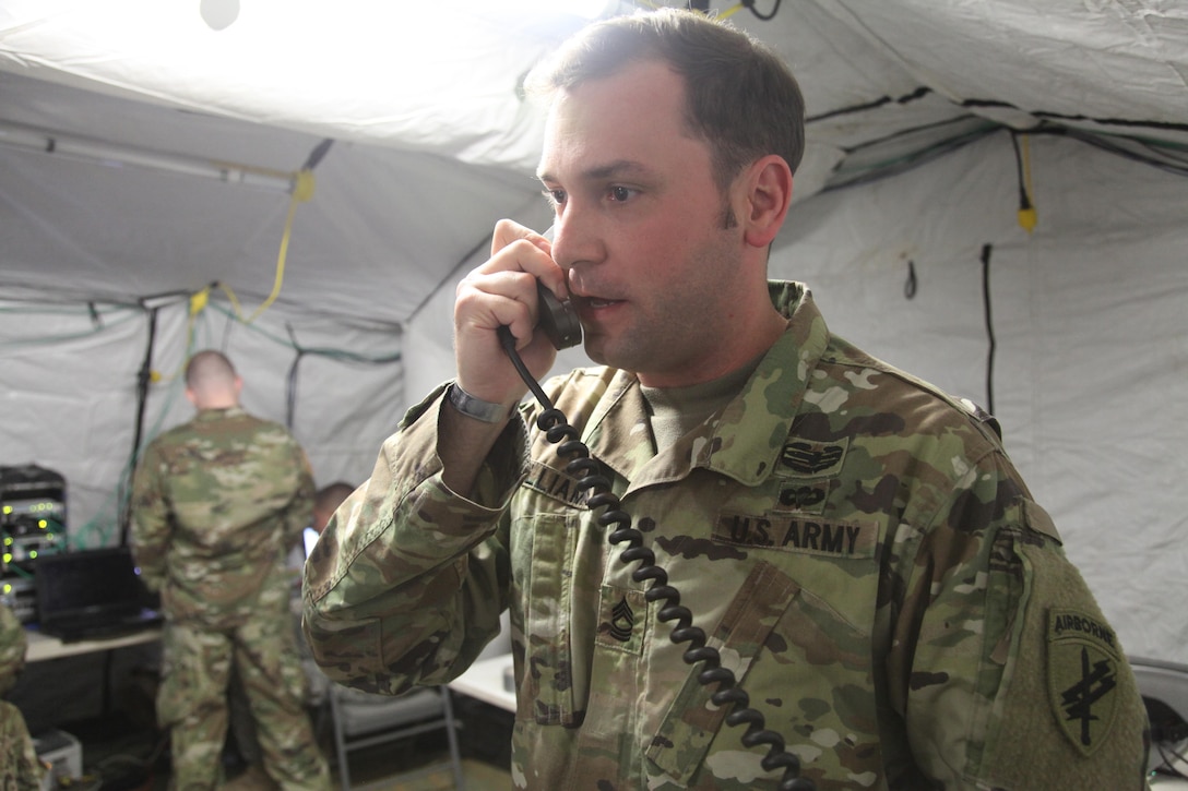 Master Sgt. Kevin Williams, U.S. Army Civil Affairs & Psychological Operations Command (Airborne), relays information during an airborne operation, for the XIX Annual Randy Oler Memorial Operation Toy Drop, hosted by U.S. Army Civil Affairs & Psychological Operations Command (Airborne), at Luzon Drop Zone on Dec. 12, 2016. Operation Toy Drop is the world’s largest joint and combined airborne operation and collective training exercise with paratroopers from eight partner-nations. (U.S. Army photo by Spc. Lisa Velazco/Released)