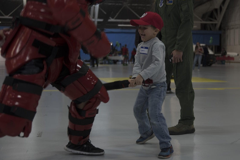 Gabriel, 2016 Parents and Children Fighting Cancer Christmas Party attendee, performs a Redman suit demonstration with Senior Airman Benjamin Oviedo, 811th Security Support Squadron executive aircraft security team member, at Joint Base Andrews, Md., Dec. 10, 2016. The JBA Fisher House sponsored the annual event during which attendees were able to take part in demonstrations with JBA team members. The 811th SSPTS uses the suit to train in hand-to-hand combat. (U.S. Air Force photo by Airman 1st Class Rustie Kramer)