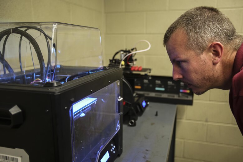 A member of the Office of Naval Research observes one of 2nd Maintenance Battalion’s 3D printers during a brief to show the scientists its capabilities at Camp Lejeune, N.C., Dec. 8, 2016. The staff of the ONR visited the base as part of the Scientist to Field Program for the research community to better understand the operational environment. (U.S. Marine Corps photo by Lance Cpl. Miranda Faughn)