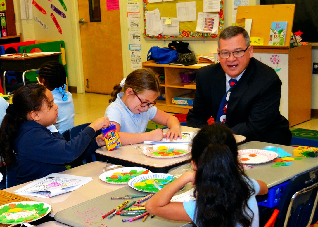 Richard Ellis, DLA Troop Support deputy commander, talks with kindergarten and first-grade students of Benjamin Franklin Elementary School as they make crafts during the annual Children’s Holiday Party Dec. 8. Troop Support employees donated gifts and played games with students during the party.