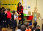 Darnesha King, an intern with the Construction and Equipment supply chain, leads Benjamin Franklin Elementary School students in a game during the annual Children’s Holiday Party Dec. 8. Troop Support employees donated gifts for more than 200 students for the party.