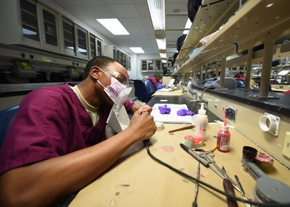 Airman Joshua Terry, a dental laboratory apprentice course trainee, practices fabricating dentures at the Medical Education and Training Campus on Joint Base San Antonio-Fort Sam Houston, Oct. 20, 2016. The 6-month technical training course is comprised of 5 different courses, each of which focuses on a specific skill set. While in training, the students are assigned to the 381st Training Squadron. (U.S. Air Force photo/Staff Sgt. Jerilyn Quintanilla) 