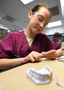 Airman 1st Class Brianna Benko, a dental laboratory apprentice course trainee, practices fabricating partial dentures at the Medical Education and Training Campus on Joint Base San Antonio-Fort Sam Houston, Oct. 20, 2016. The course is one of several technical training courses that are tri-service with each class averaging approximately 7 Airmen, 6 Sailors and 8 Soldiers. (U.S. Air Force photo/Staff Sgt. Jerilyn Quintanilla) 