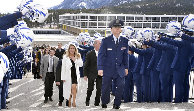 Brittany Bird (in white), wife of retired Capt. Carson Bird, walks up the steps to the Cadet Chapel while members of the Air Force Falcons hold their helmets aloft in salute to her husband, Dec. 9, 2016 at the U.S. Air Force Academy. Carson Bird, a 2008 Academy graduate and all-star cornerback, died Nov. 26, 2016, after battling Chondrosarcoma, a rare form of bone cancer. (U.S. Air Force photo/Jason Gutierrez) 