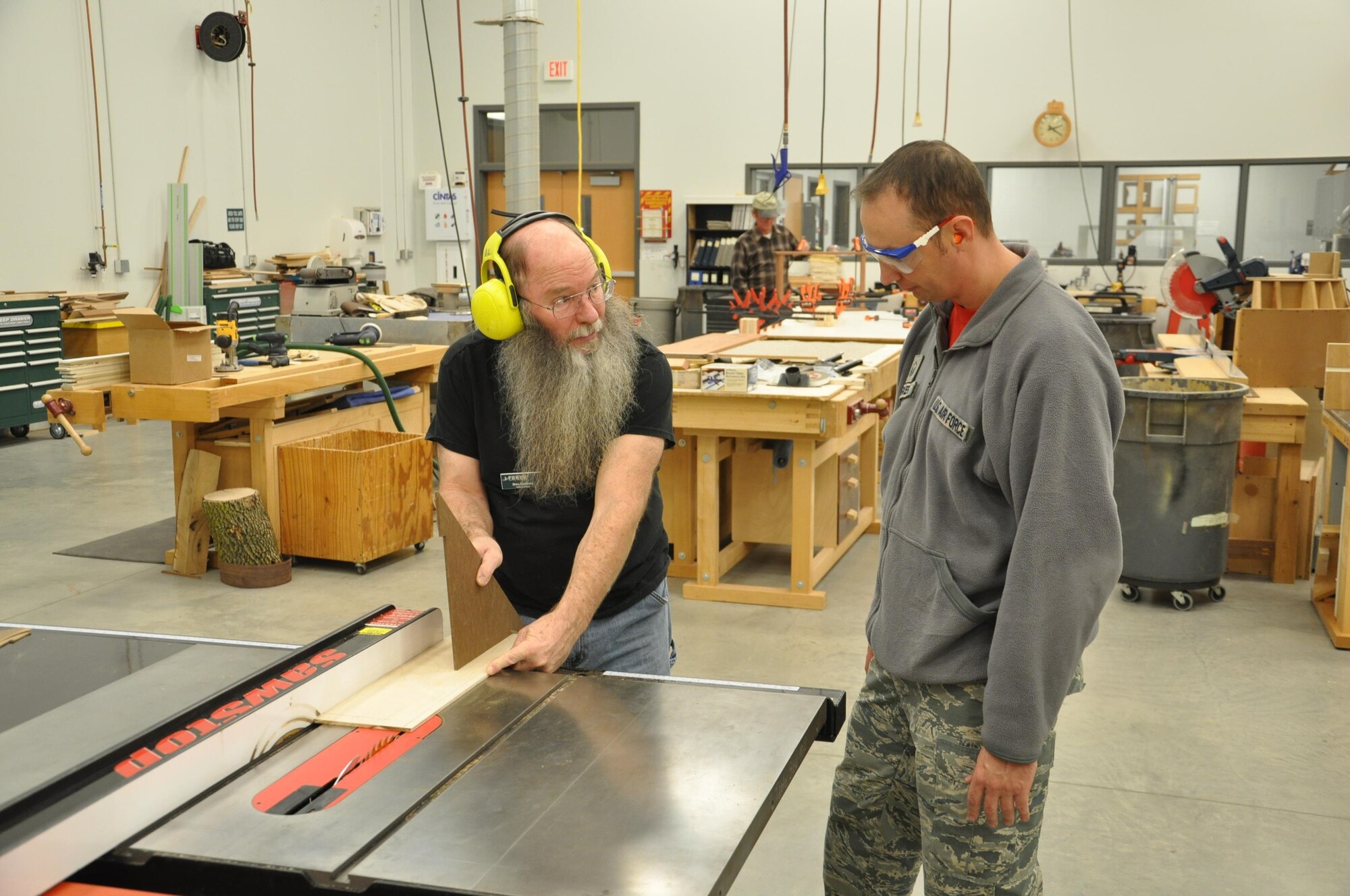Don Lindsly, woodworker, helps do-it-yourselfer Master Sgt. Wylie Parker, measure a piece of hardwood before cutting it on a circular table saw at the woodshop, located in the Consolidated Hobby Complex, Bldg. 1227 in the Kittyhawk area. (U.S. Air Force photo/W. Eugene Barnett)