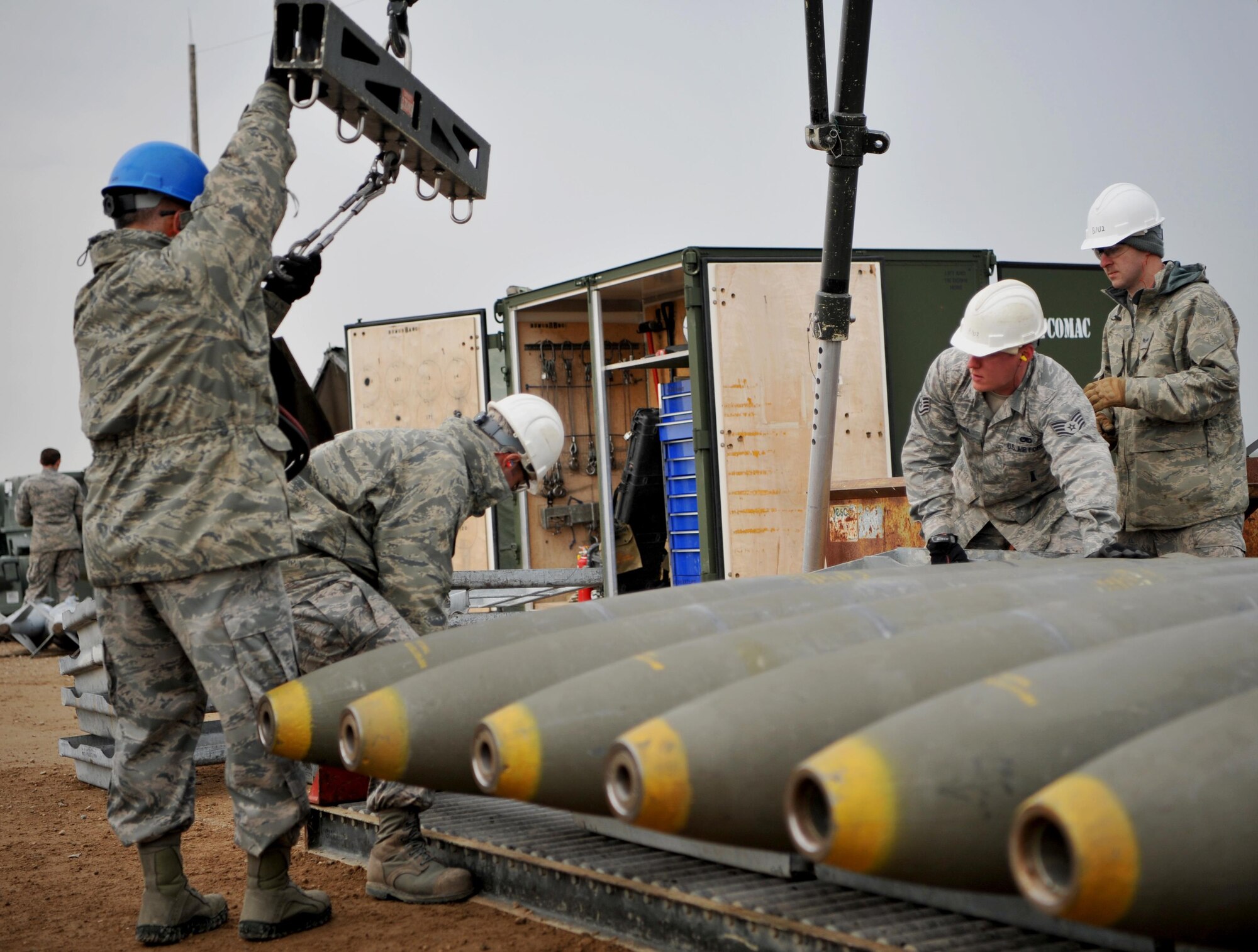 Enlisted Airmen and officers work together to load munitions at the munitions pad Dec. 13, 2016, at Beale Air Force Base, California. The munitions build is part of the Senior Officer Orientation course that immerses and familiarizes officers with the core training enlisted Airmen receive in the munitions career field. (U.S. Air Force photo/Staff Sgt. Jeffrey Schultze) 