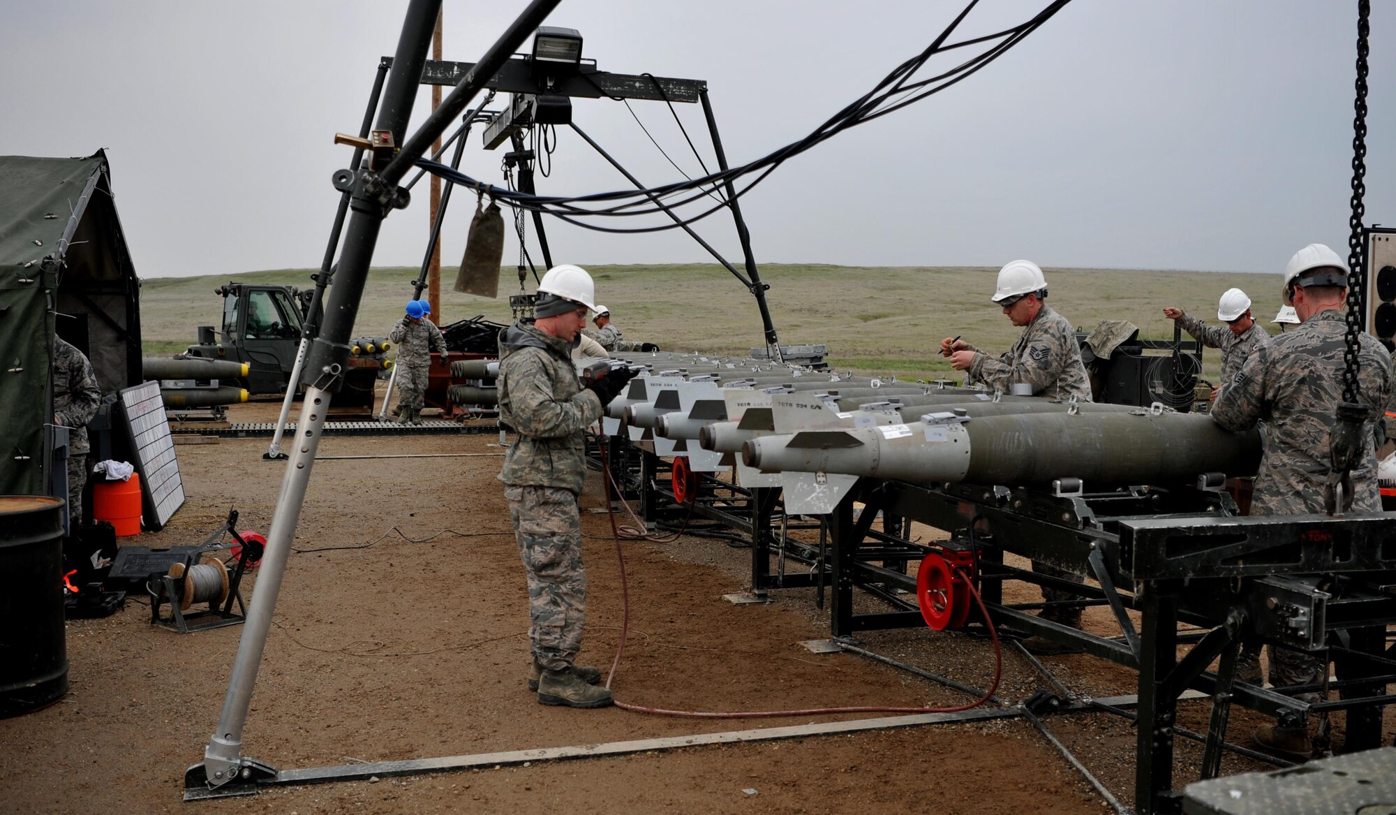 Enlisted Airmen and officers work together to build munitions at the munitions pad Dec. 13, 2016, at Beale Air Force Base, California. The munitions build is part of the Senior Officer Orientation course that immerses and familiarizes officers with the core training enlisted Airmen receive in the munitions career field. (U.S. Air Force photo/Staff Sgt. Jeffrey Schultze)