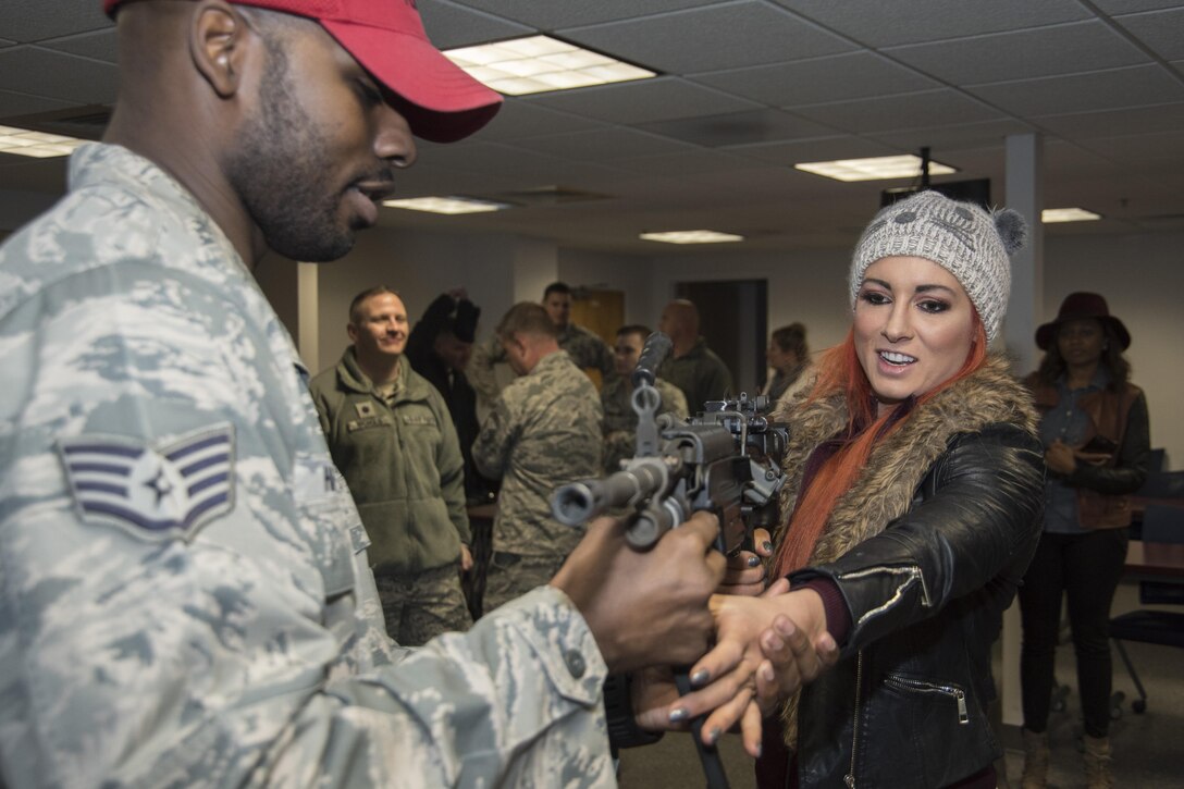 Staff Sgt. Eugene Harrison, 11th Security Forces Squadron member, provides basic weapons instruction to Becky Lynch, World Wrestling Entertainment Superstar, at Joint Base Andrews, Md., Dec. 13, 2016. In addition to laying out different weapons for the Superstars to view, security forces members provided demonstrations of the security forces military working dog section, combat gear and other aspects of the unit. (U.S. Air Force photo by Senior Airman Jordyn Fetter)