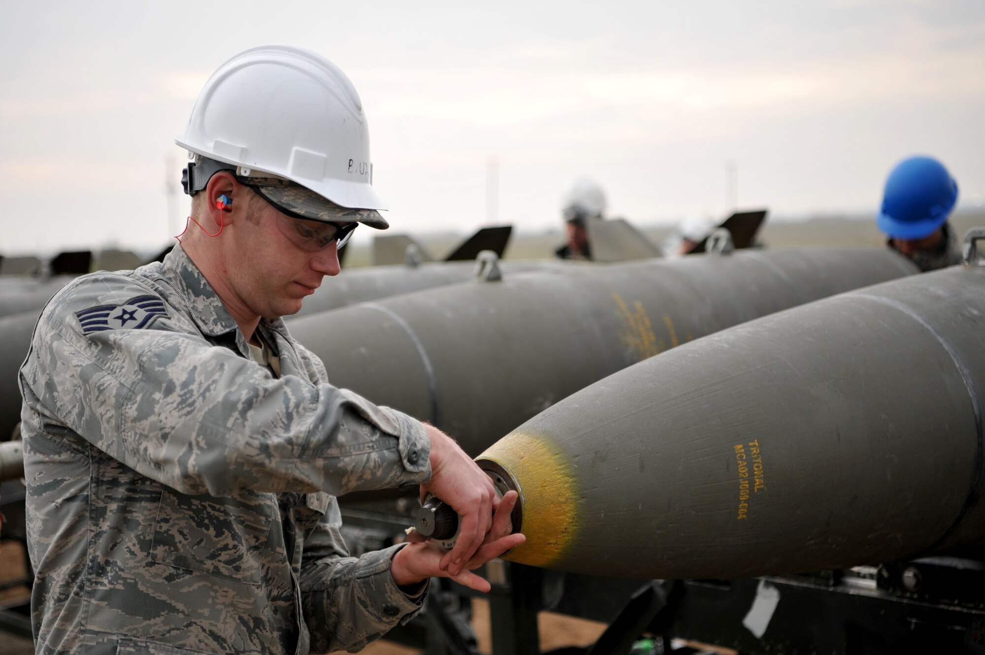 Enlisted Airmen and officers work together to build munitions at the munitions pad Dec. 13, 2016, at Beale Air Force Base, California. The munitions build is part of the Senior Officer Orientation course that immerses and familiarizes officers with the core training enlisted Airmen receive in the munitions career field. (U.S. Air Force photo/Staff Sgt. Jeffrey Schultze)