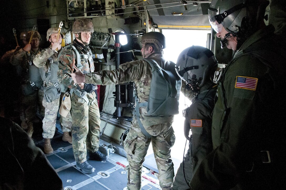 An Army jumpmaster gives the thumbs-up for paratroopers to stand before participating in airborne operations with partner nations during Operation Toy Drop at Green Ramp, Fort Bragg, N.C., Dec. 9, 2016. Army photo by Sgt. Christina M. Dion