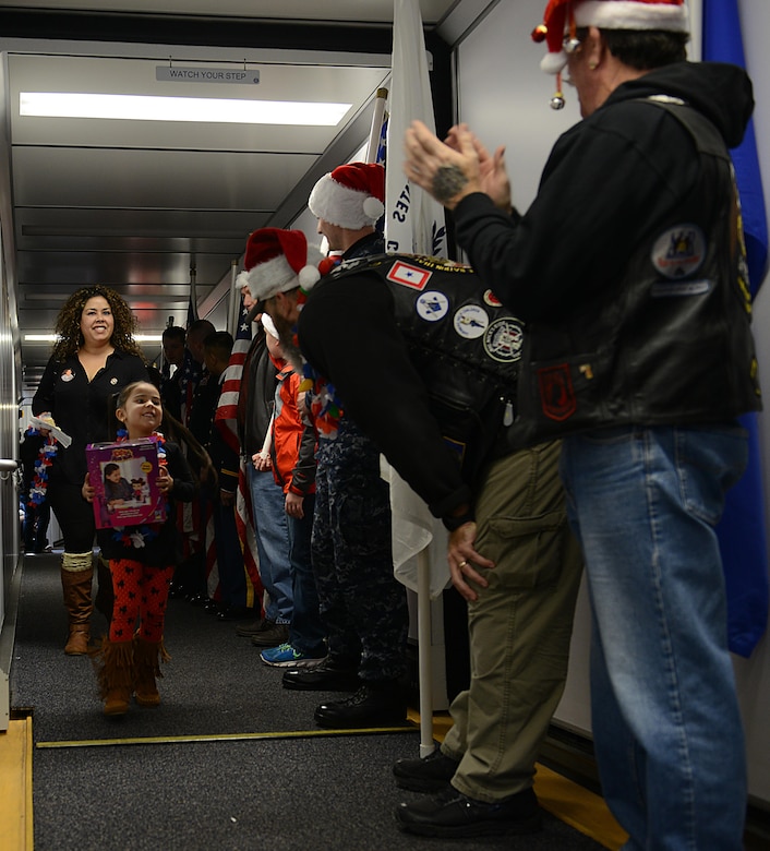 U.S. service members and the Virginia Patriot Guard cheer and escort Gold Star families onto their Snowball Express flight in Norfolk, Va., Dec. 11, 2016. This was the first year that Adriana Quintana, age 5, participated in the Snowball Express. (U.S. Air Force photo by Staff Sgt. Teresa J. Cleveland)