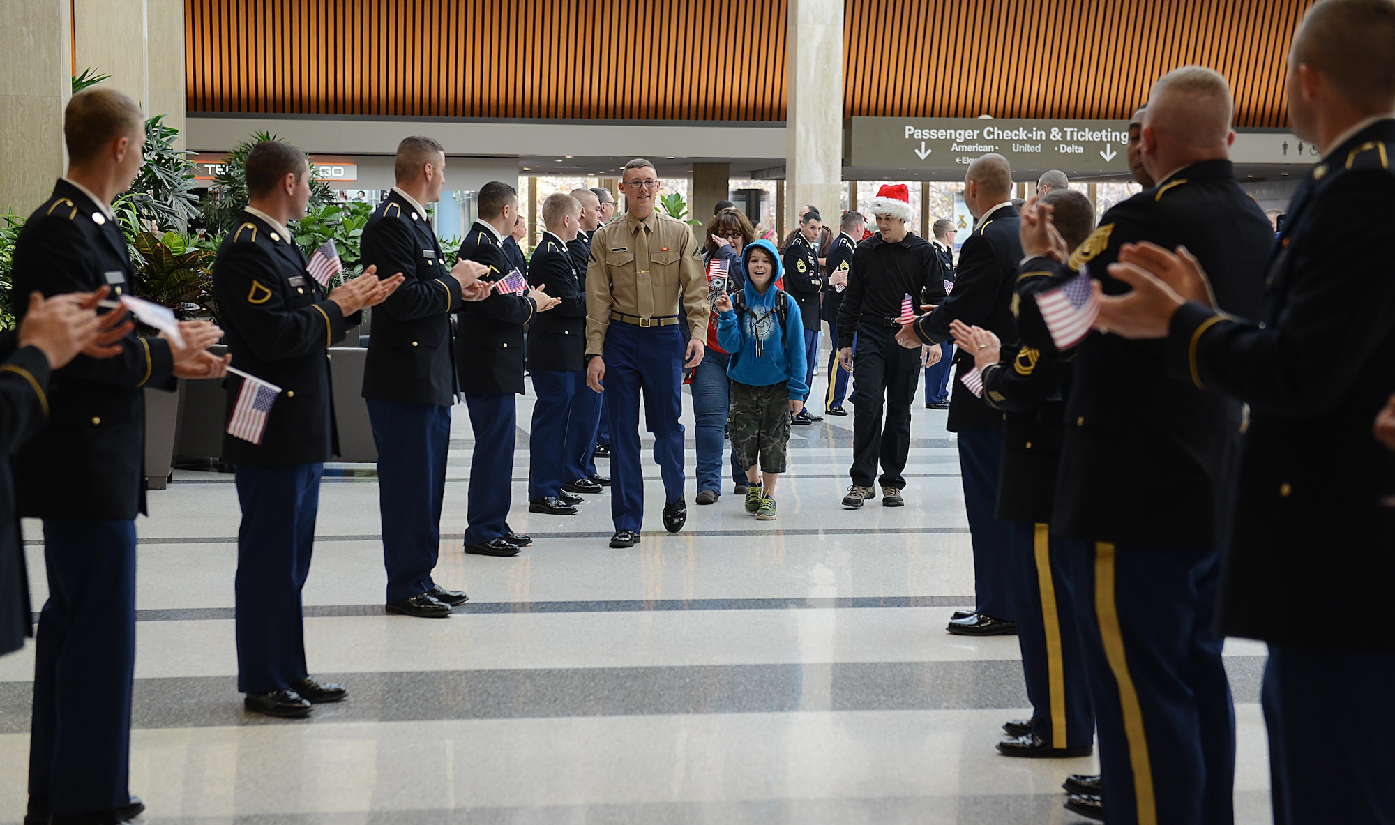 U.S. service members escort Gold Star families during the Snowball Express at Norfolk International Airport, Va., Dec. 11, 2016.  More than 300 service members and the Virginia Patriot Guard lined the airport to show support for the children of fallen service members. (U.S. Air Force photo by Staff Sgt. Teresa J. Cleveland)