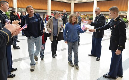 U.S. service members hand U.S. flags to Gold Star families as they leave for the Snowball Express at Norfolk International Airport, Norfolk, Va., Dec. 11, 2016. Gold Star families traveled to Dallas on a four-day, all expenses paid trip to thank them for their family member’s sacrifice. (U.S. Air Force photo by Staff Sgt. Teresa J. Cleveland)