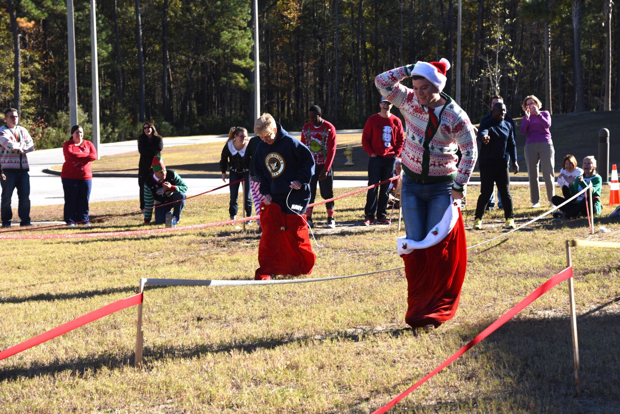 Naval Health Clinic Charleston Executive Officer Capt. Kathleen Hinz, left, and Seaman Edward Duncan, a general duty corpsman, compete in "Santa's Sack Race" during NHCC's "Reindeer Games" competition Dec. 9 at NHCC. The team
building activity included four six-person teams competing in five "Minute to Win it"- type challenges.
