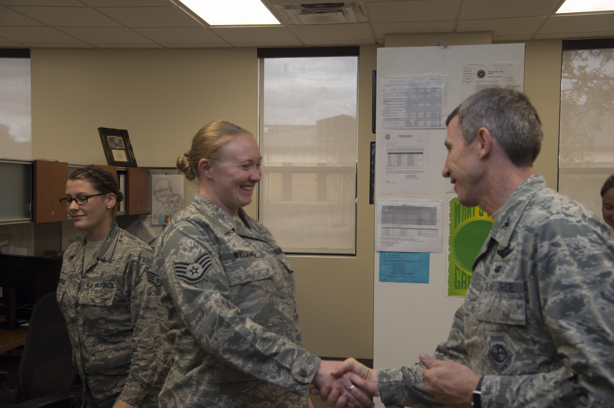 Staff Sgt. Jennifer Williams, 23d Bioenvironmental Engineering Flight NCO in charge of occupational health and safety, receives a coin from Col. Thomas Kunkel, 23d Wing commander Dec. 12, 2014, at Moody Air Force Base, Ga. Williams was recognized for her hard work and leadership in the flight. (U.S. Air Force photo by Staff Sgt. Eric Summers Jr.)